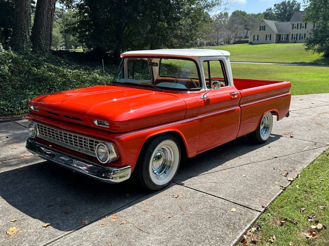 Orange 1963 Chevrolet C10 Fleetside pickup with a white roof in a driveway