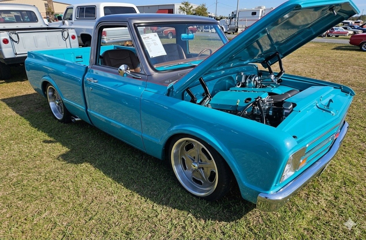 Teal 1967 Chevrolet C10 fleetside pickup with the hood raised at a car show